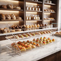 Espositore a tre ripiani in plexiglass trasparente con dolci e finger food sul bancone di una pasticceria